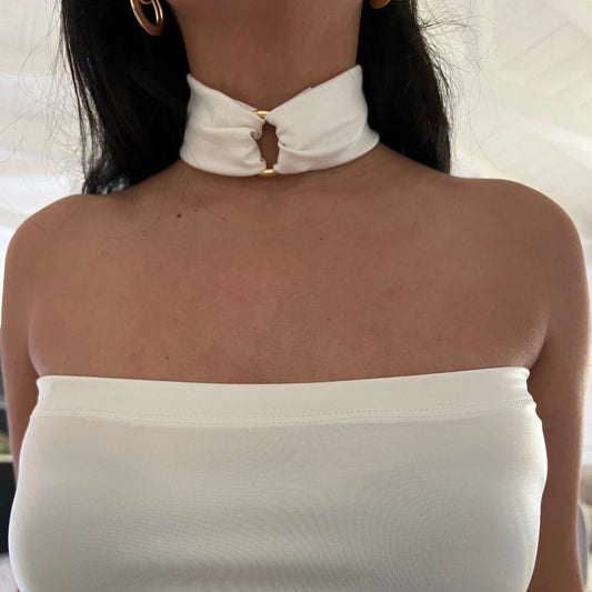 This image features an elegant white faux leather choker necklace, designed with a luxurious touch. The necklace is adorned with a central O-ring embellished with an 18K gold-plated stainless steel ring, adding a touch of sophistication and glamour.